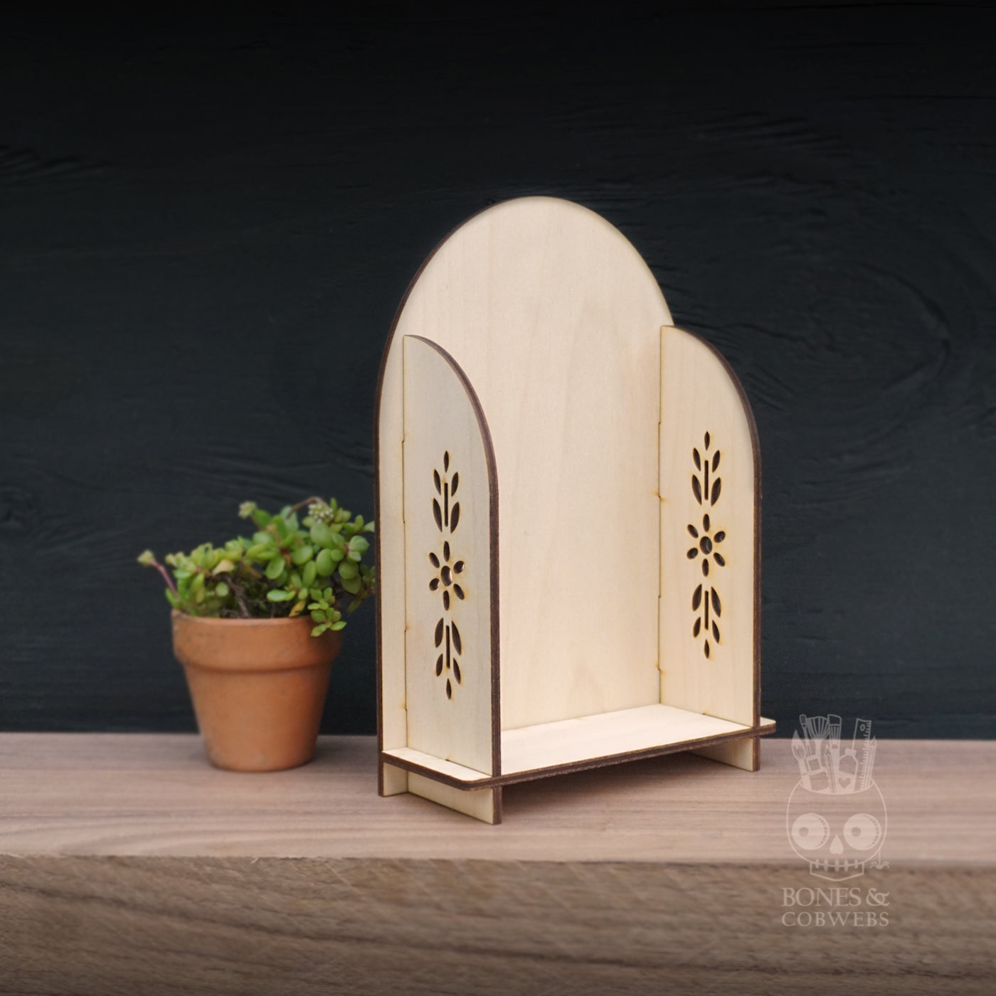 Wooden decorative shelf with floral patterns on a wooden surface and dark background