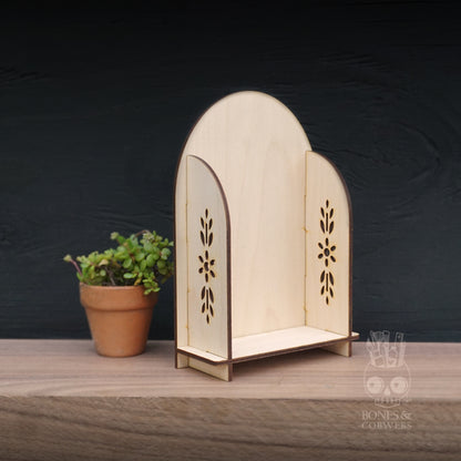 Wooden decorative shelf with floral patterns on a wooden surface and dark background